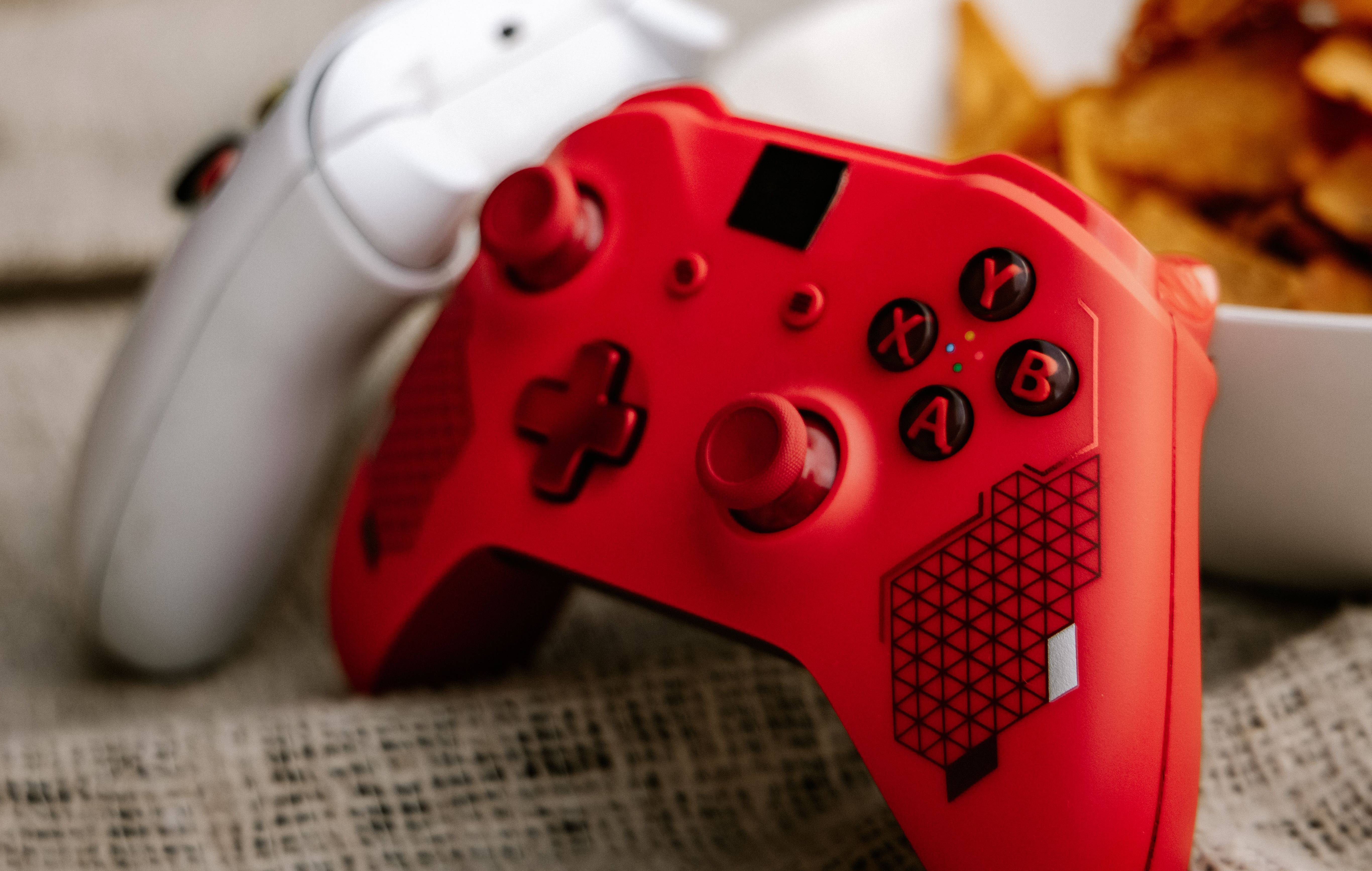 A pair of game controllers, one red and one white